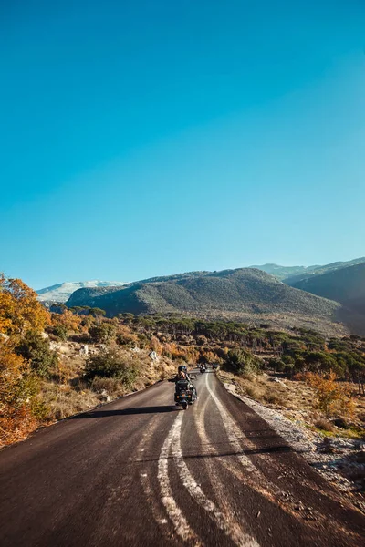 アクティブな人々のグループは 山の中の道路に沿ってバイクに乗っている 自由と極端なスポーツを楽しむ 幸せな健康的なライフスタイル — ストック写真