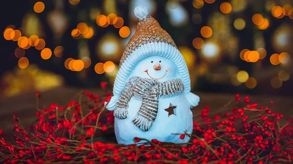 漂亮的圣诞家居装饰 可爱的小雪人玩具 站在红莓花环上 在明亮的圣诞树灯台上 新年快乐 — 图库照片