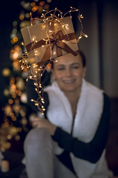 아름다운 황금색 상자는 여성의 흐르는 크리스마스 조명으로 장식되어 집에서 겨울날을 — 스톡 사진