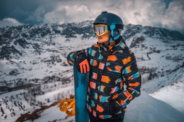 Dişi Snowboard 'cu. Dağın tepesinde Snowboard' la dikiliyor. Smowboardcu Outfit. Ekstrem Kış Sporu. Mutlu Aktif Kış Tatilleri.