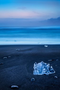 Buzdağları olan siyah volkanik bir kumsal manzarası. Vatnajokull Jokulsarlon 'un Serene Nature' ı. İzlanda. 