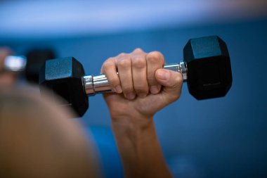 Fotoğraf: Seçici Odaklanma: Dumbbell ile Bir Kadının Eli Üzerine Odaklanma. Spor salonunda idman yapıyorum. Kilo kaybediyor. Güçlü kaslar. Sağlıklı Spor Yaşam Tarzı.