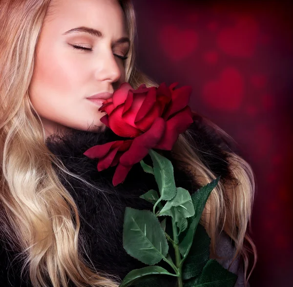 Schöne Frau duftende Rose — Stockfoto