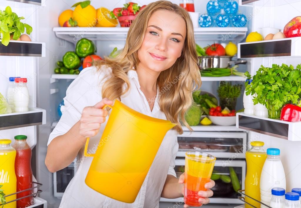 Happy woman pouring juice