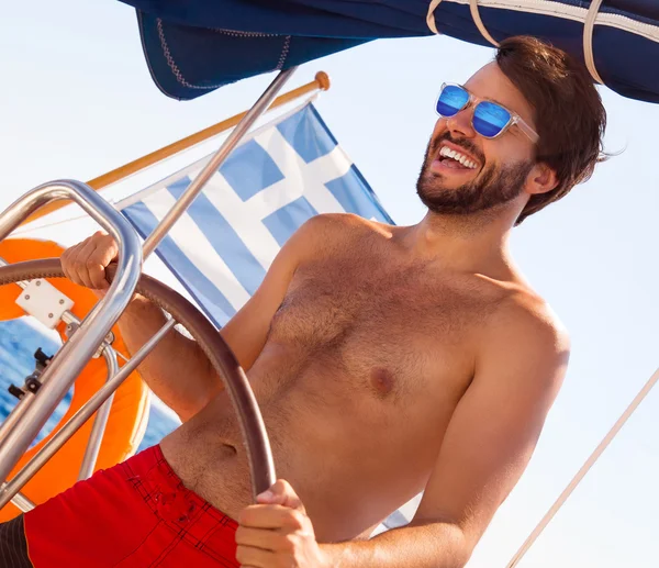 Homem bonito dirigindo veleiro — Fotografia de Stock