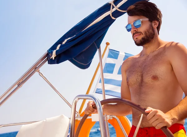 Homem bonito dirigindo veleiro — Fotografia de Stock