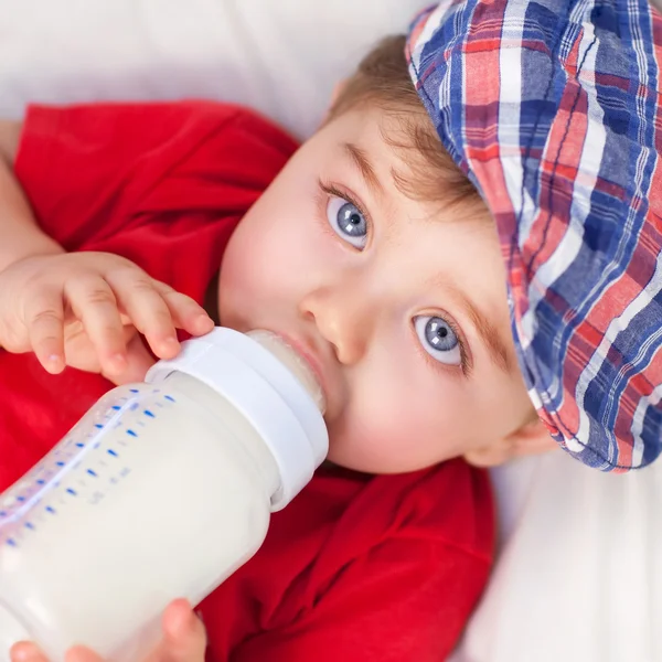 Hungry little boy drinking milk — Stock Photo, Image