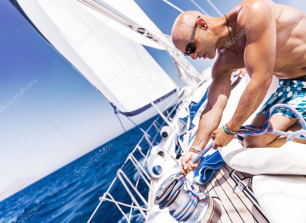 Handsome sailor on sailboat