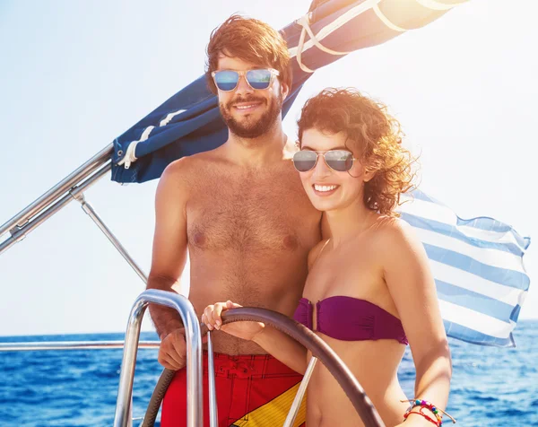 Joyful couple driving sailboat — Stock Photo, Image