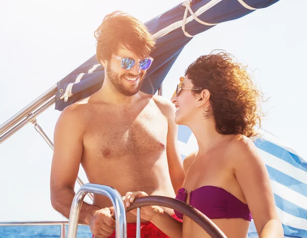 Cheerful couple driving sailboat — Stock Photo, Image