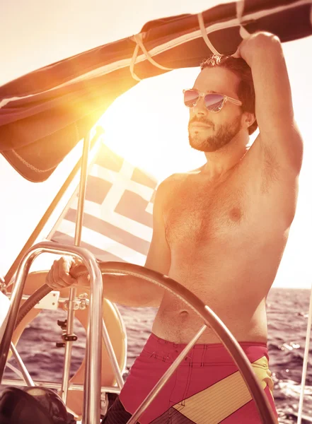 Handsome guy driving sailboat — Stock Photo, Image