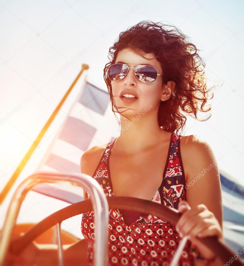 Beautiful woman driving sailboat
