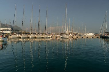 Akşamları yelkenli limanı, limanda birçok lüks yelkenli, gemi direkleri suya, Hırvatistan 'da marinaya, yaz tatillerine yansıyor