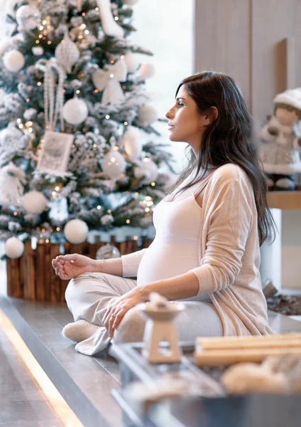 Έγκυος γυναίκα κοντά στο χριστουγεννιάτικο δέντρο — Φωτογραφία Αρχείου