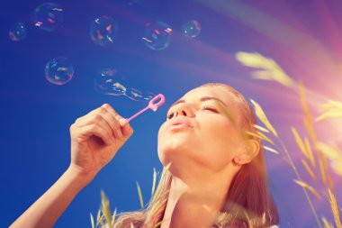 Pretty woman blowing soap bubbles
