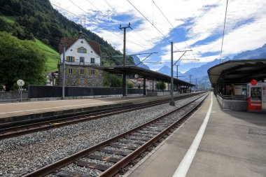 Fluelen, İsviçre - 25 Ağustos 2020: Tren istasyonunda tren yok. Platformda tren bekleyen insanlar var..