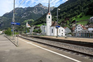 Fluelen, İsviçre - 25 Ağustos 2020: Demiryolu raylarının arkasında, iki kilise bu güzel kasabanın manzarasını tamamlıyor.