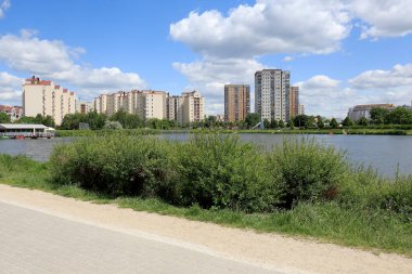 Varşova, Polonya - Haziran 02, 2020: Göl kenarındaki kaldırım çok aile binalarına doğru gidiyor. Bu manzara Goclaw adında yerel bir konutta görülebilir..