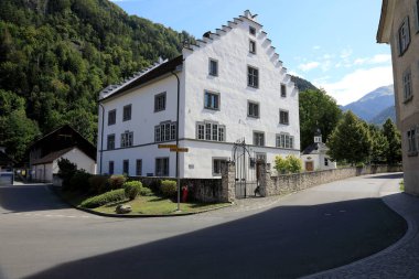 Altdorf, İsviçre - 27 Ağustos 2020: Dar bir sokakta beyaz cepheli bir ev var. Ev çelik kapılı taş bir duvarla çevrili..