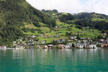 Lucerne Gölü 'nün kıyısındaki tepenin yamacındaki konut binaları uzaktan görülebilir. Dört Kantonun Gölü.