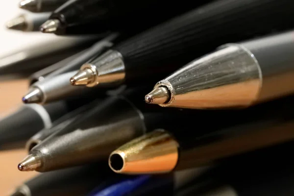 Some miscellaneous used ball pens in a pile. Office accessories.