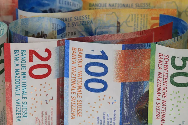 Swiss money. Swiss franc banknotes have been rolled up and placed side by side. CHF currency.