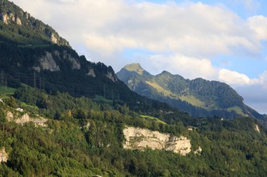 Gökyüzünün bulutlar tarafından biraz gizlenmiş olduğu bir dağ sırası. Bu manzara İsviçre 'deki Schwyz kantonunda Brunnen' den görülebilir..