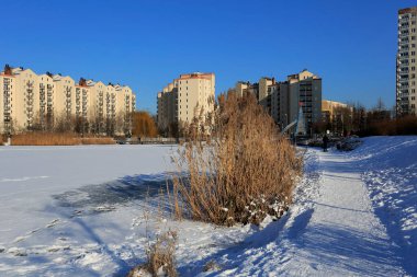 Varşova, Polonya - 31 Ocak 2021: Goclaw malikanesindeki apartman ve parkların kış manzarası. Göl karla kaplı..