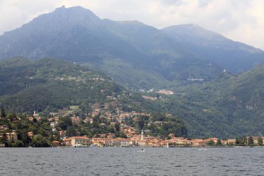 Menaggio, İtalya - 12 Temmuz 2009: Como Gölü kıyısında yer alan binalar manzaralı bir manzara yaratıyor. Biraz ileride bir tepe daha var..