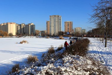Varşova, Polonya - 31 Ocak 2021: Park ve göl, burada güneşli bir kış günü görülebilen ve yerel olarak Goclaw olarak adlandırılan yerleşim alanının bir parçasıdır..