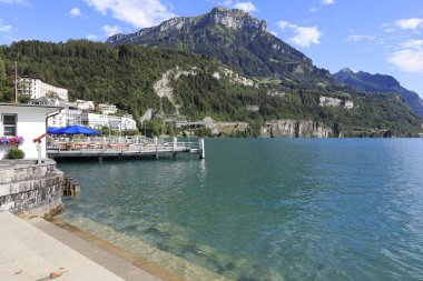 Brunnen, İsviçre - 25 Ağustos 2020: İskelenin arkasında bir grup bina ve büyük bir tepe görebilirsiniz. Schwyz Kantonu 'nun Ingenbohl ilçesine bağlı bir beldedir..