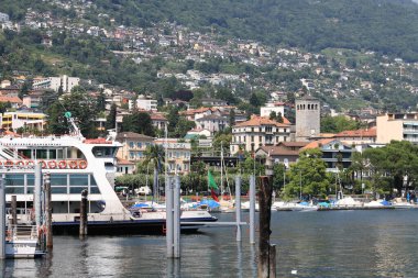 Locarno, İsviçre - 13 Temmuz 2009: Motor gemisi Maggiore Gölü 'ndeki gemi terminalinde durdu. Kıyıda ve yakındaki tepede şehrin çok sayıda konut binaları vardır..