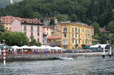 Varenna, İtalya - 12 Temmuz 2009: Como Gölü kıyısındaki liman bölgesi. Otel ve konut binalarının yanı sıra yamaçtaki ağaçlar da biraz daha uzakta..