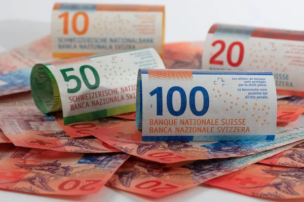 Swiss money. Swiss franc banknotes have been rolled up and placed side by side. CHF currency.