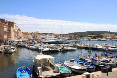 Saint-Tropez, Fransa - 8 Temmuz 2009: Yatlar marinada demirli ve arkalarında Akdeniz 'de bulunan evler var. Burası Fransız Rivierası 'nda en çok ziyaret edilen yerlerden biri..