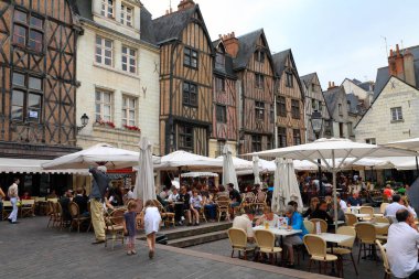 Tours, Fransa - 12 Haziran 2010: 15 'inci yüzyıla dayanan yarı keresteli evler Plumereau Meydanı' nın mimari bir dekorasyonudur. Burada hayat kafe ve restoranlarda kaynıyor..
