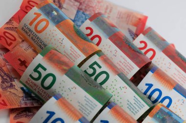 İsviçre parası. İsviçre frangı yuvarlandı ve yan yana yerleştirildi. CHF para birimi.