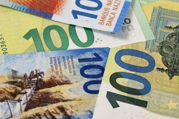 The euro banknotes and Swiss paper money placed together express the relationship between the Swiss franc and the currency of the European Union. EUR and CHF currencies.