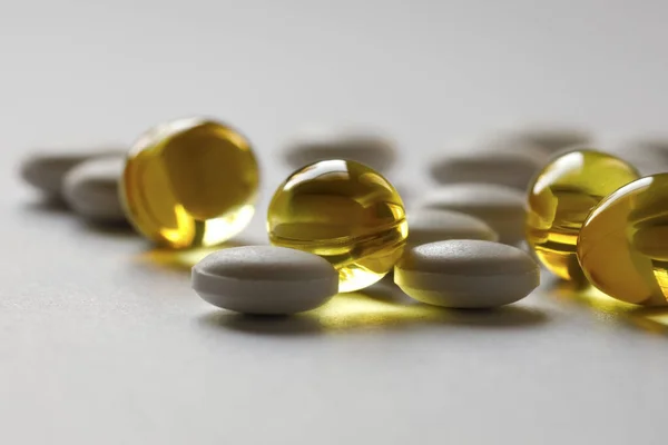 Tablety Tobolky Jsou Roztroušeny Povrchu Bílého Papíru Jedná Léčivé Přípravky — Stock fotografie