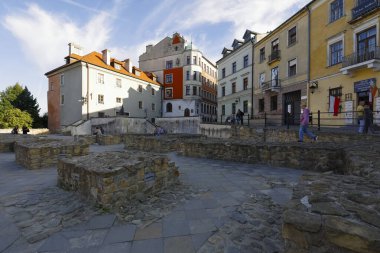 Lublin, Polonya - 10 Eylül 2021: kaldırıma yakın eski kasaba binaları. İnsanlar zamanlarını bölgeyi izleyerek geçiriyorlar.