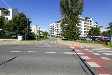 Varşova, Polonya - 3 Eylül 2021: Pek çok ailenin yaşadığı Goclaw konut semtindeki apartmanlar güneşli bir günde ağaçlar ve bitkiler arasında görülebilir.