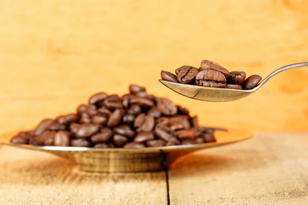 Coffee beans in a spoon — Stock Photo, Image