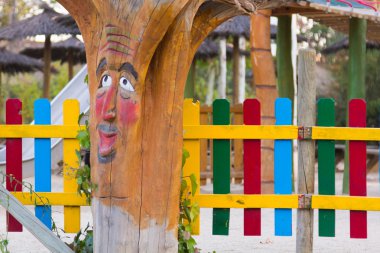 çocukça bir parkta bir yüz ile süslenmiş ağaç gövdesi