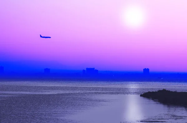 Pôr-do-sol romântico com avião no céu em rosa e azul — Fotografia de Stock