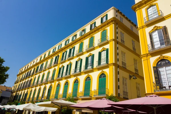 Eleganta gula hus med gröna fönster i staden Malaga, — Stockfoto