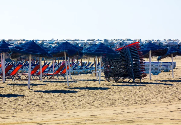 Шезлонги и зонтики готовы к установке на пляже — стоковое фото