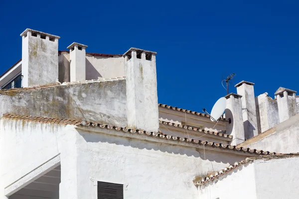 Schoorstenen op de daken van sommige witte huizen — Stockfoto
