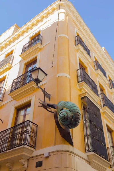 Gebäude mit großer Bronzeschnecke, die auf dem — Stockfoto