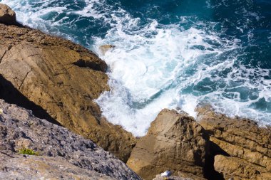 Okyanus dalgaları beyaz köpük ile buzlu gürültüyle çarpmak