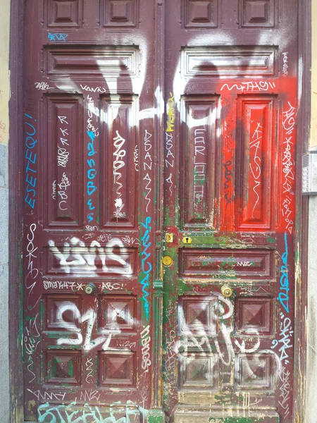 Деревянная дверь, полная граффити — стоковое фото
